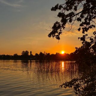 Wo kann man schon beim schwimmen dem Glockengeläut der Dorfkirche lauschen?
Wo die Zugspitze und das Estergebirge vom Wasser aus bestaunen? 
Wo einfach auf der Wiese am See liegen und den Sonnenuntergang erleben?
Am „Froschsee“ vor den Toren Murnaus!
Willkommen im SCHELLENWIES*****! 
So geht Urlaub im Blauen Land …